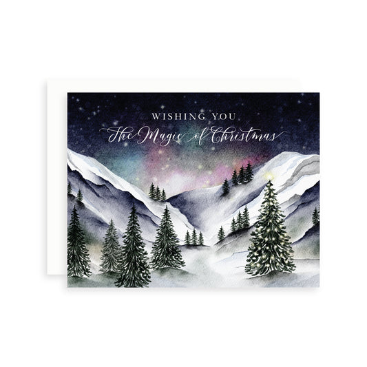 Christmas card with a watercolor snowy mountain landscape and 'Wishing you the Magic of Christmas' text.