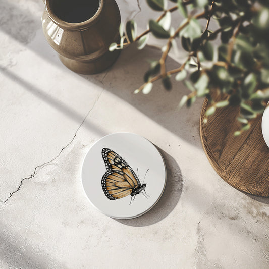 Set of 4 round stone ceramic coasters featuring a watercolor butterfly illustration on a white background