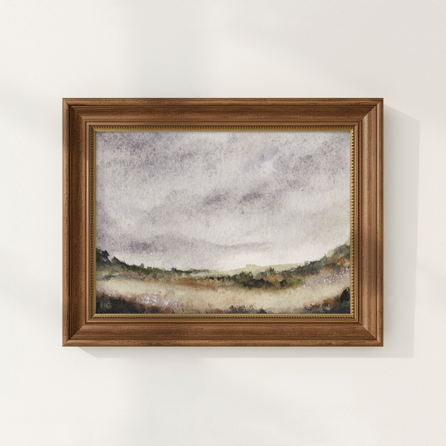 Framed landscape painting on a white wall