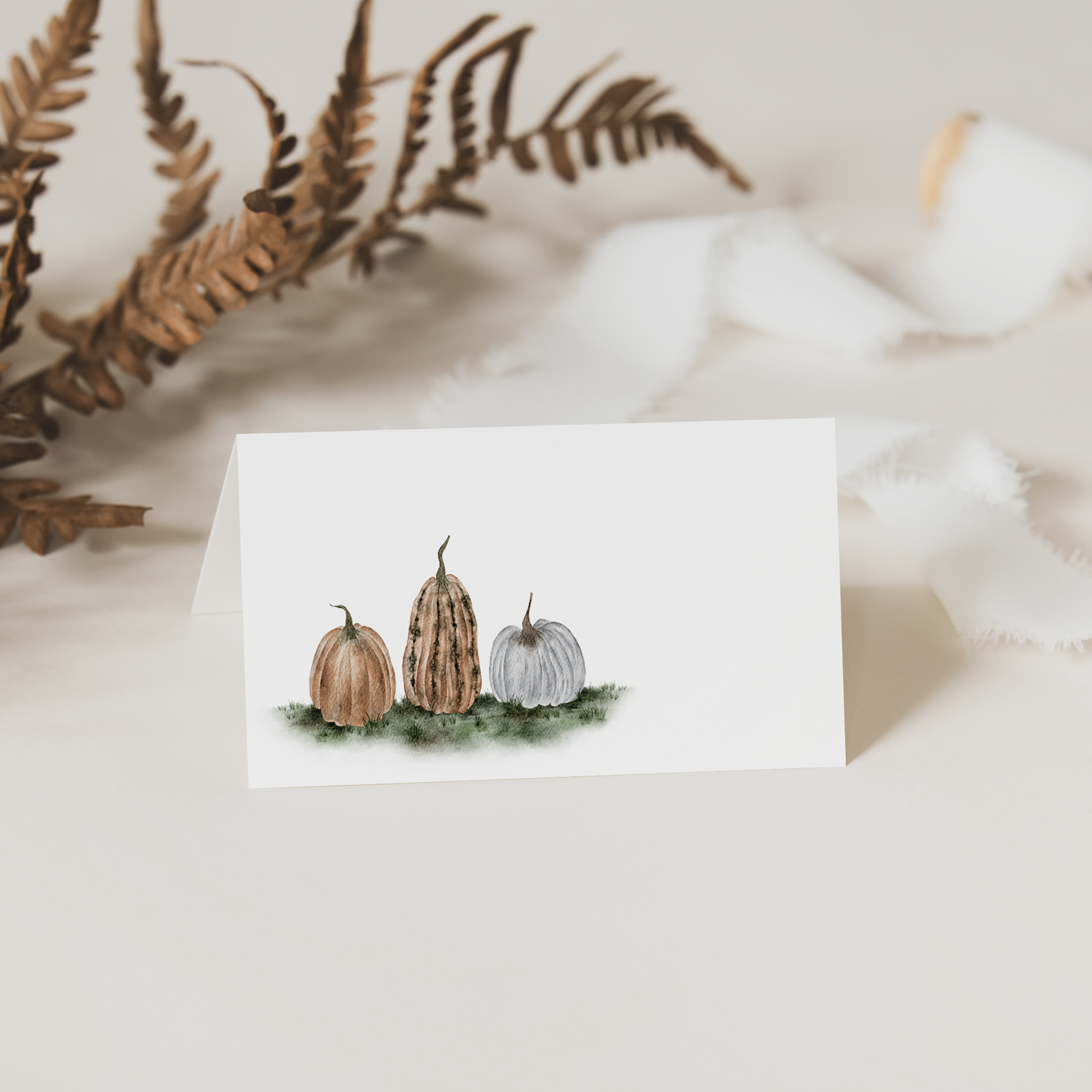 Folded place card with pumpkin illustrations on a white background
