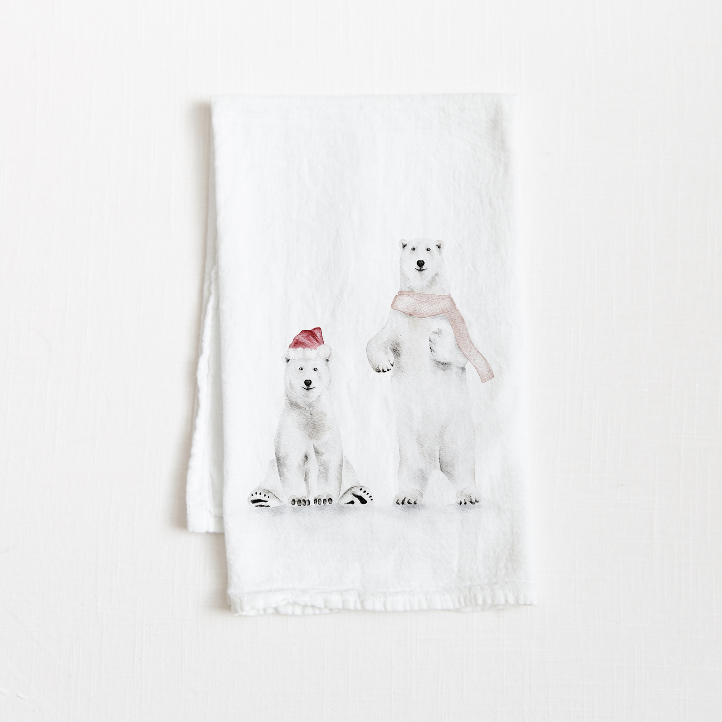 Tea towel with two watercolor holiday polar bears on a white background