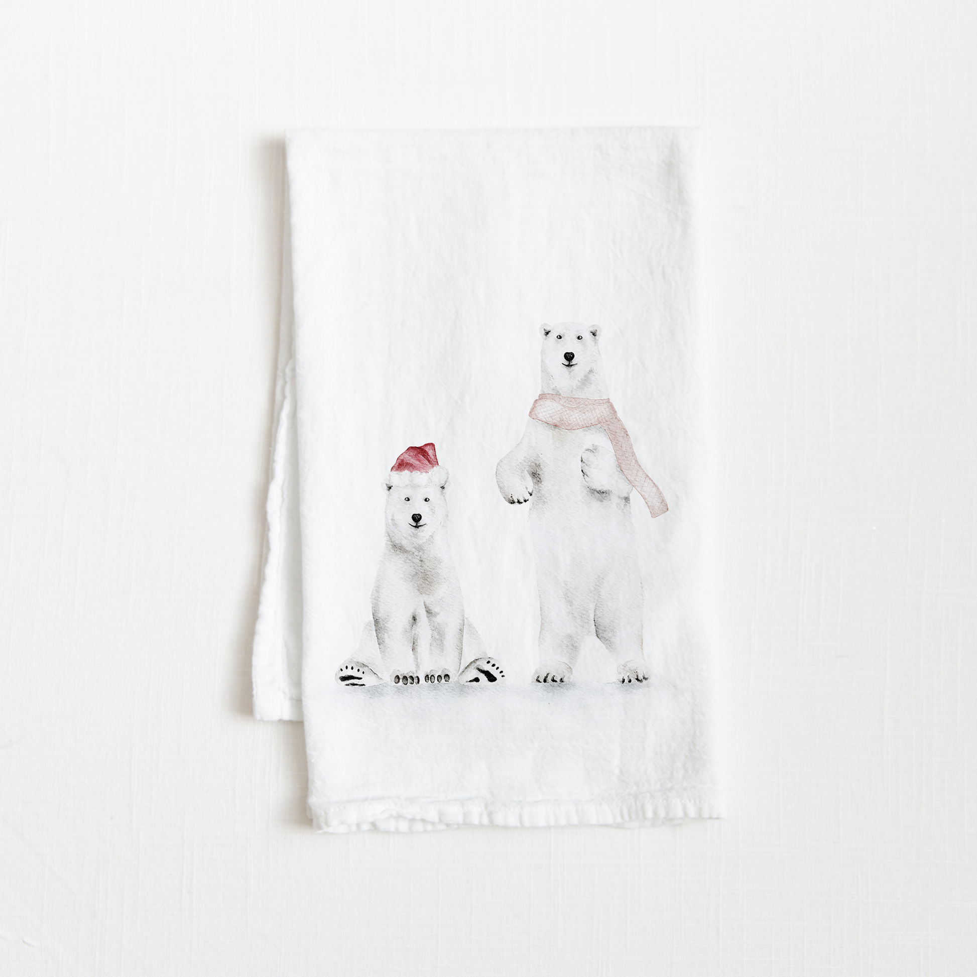 Tea towel with two watercolor holiday polar bears on a white background