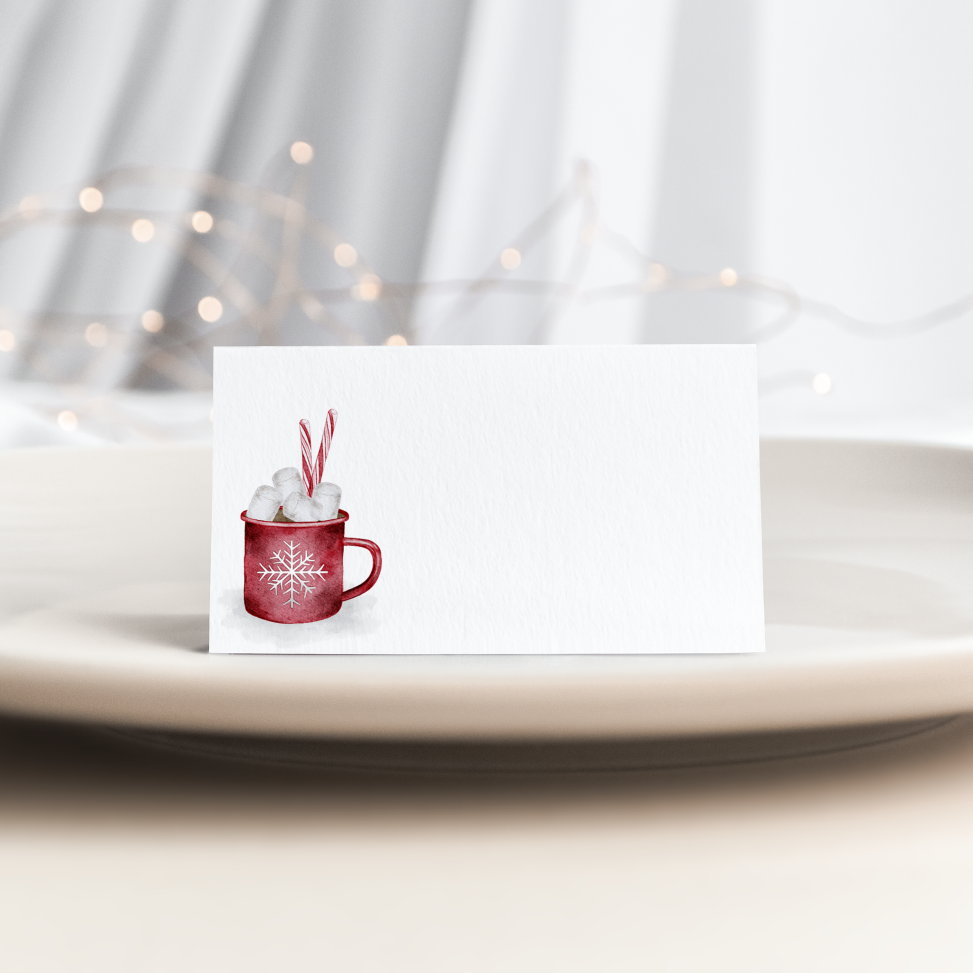 Folded place card with a red mug of hot cocoa, marshmallows and candy canes, on a white background